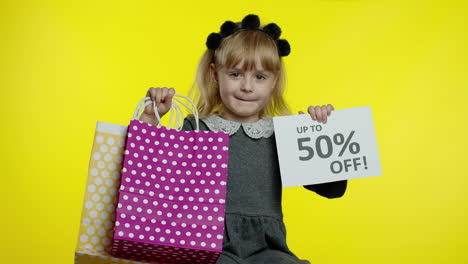 child girl showing up to 50 percent off inscription sign and shopping bags. teen pupil smiling