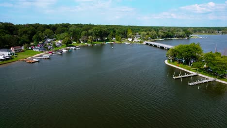 vista aérea de un pequeño puerto residencial tranquilo con barcos atracados en las orillas, capturado durante el día soleado, ubicación en el oeste de michigan, estados unidos