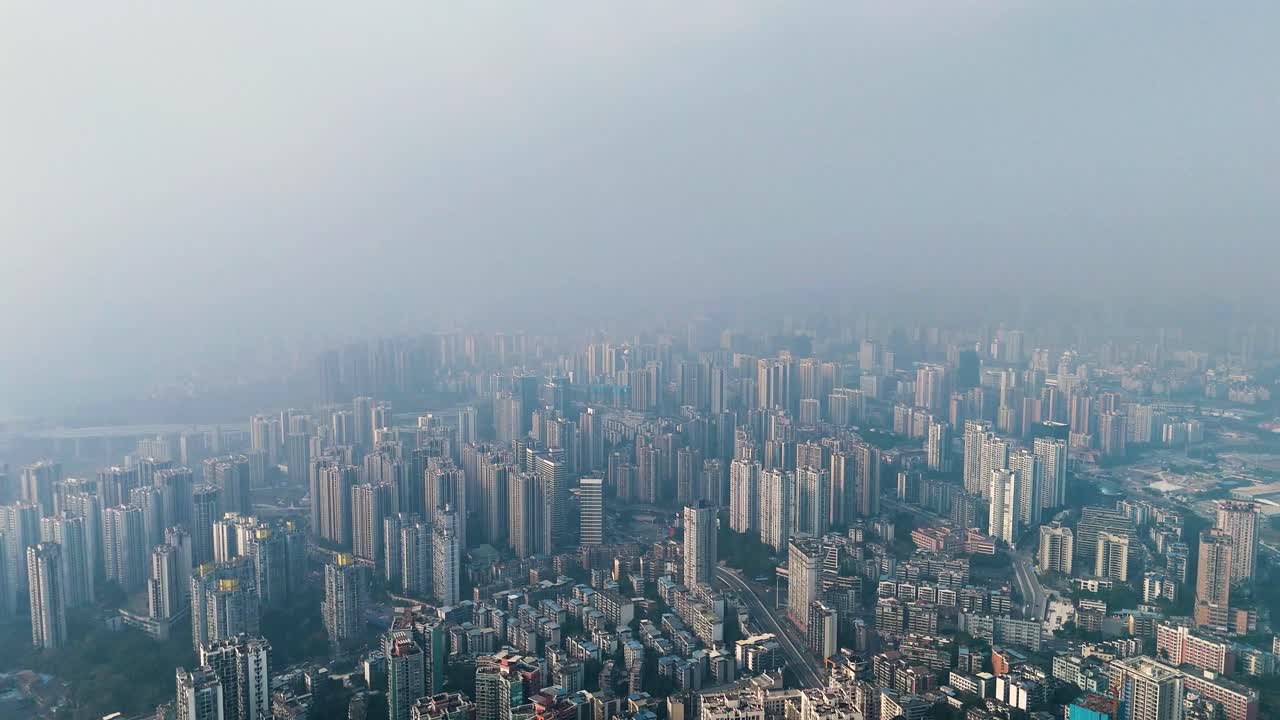 Aerial view of Chongqing city skyline covered in extreme pollution and heavy smog. Dense urban landscape with high-rise buildings fading into the haze.