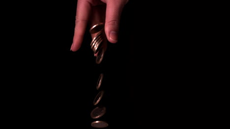 lanzamiento a mano de monedas de euro sobre un fondo negro