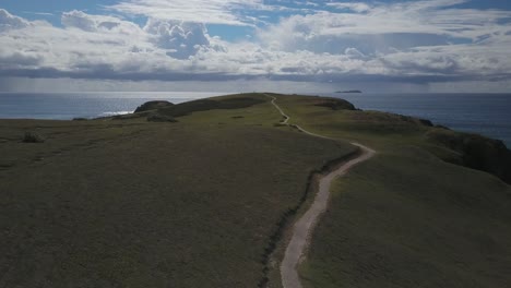 Drone-flying-over-Look-at-me-now-Headland-with-ocean-in-background,-Australia