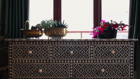 stylish decorated chest of drawers with plants and flowers