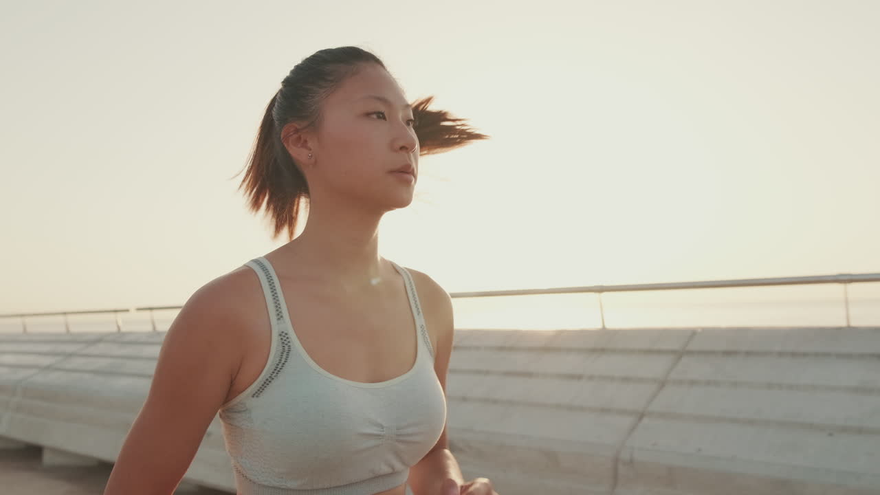 Woman running on a bridge at sunrise