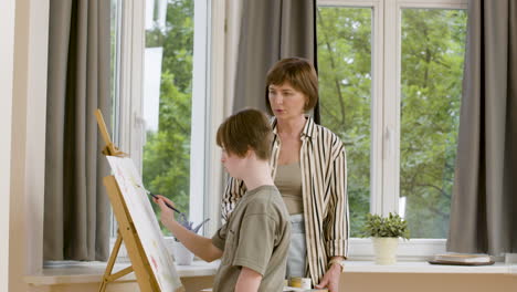 mature woman and her daughter painting at home