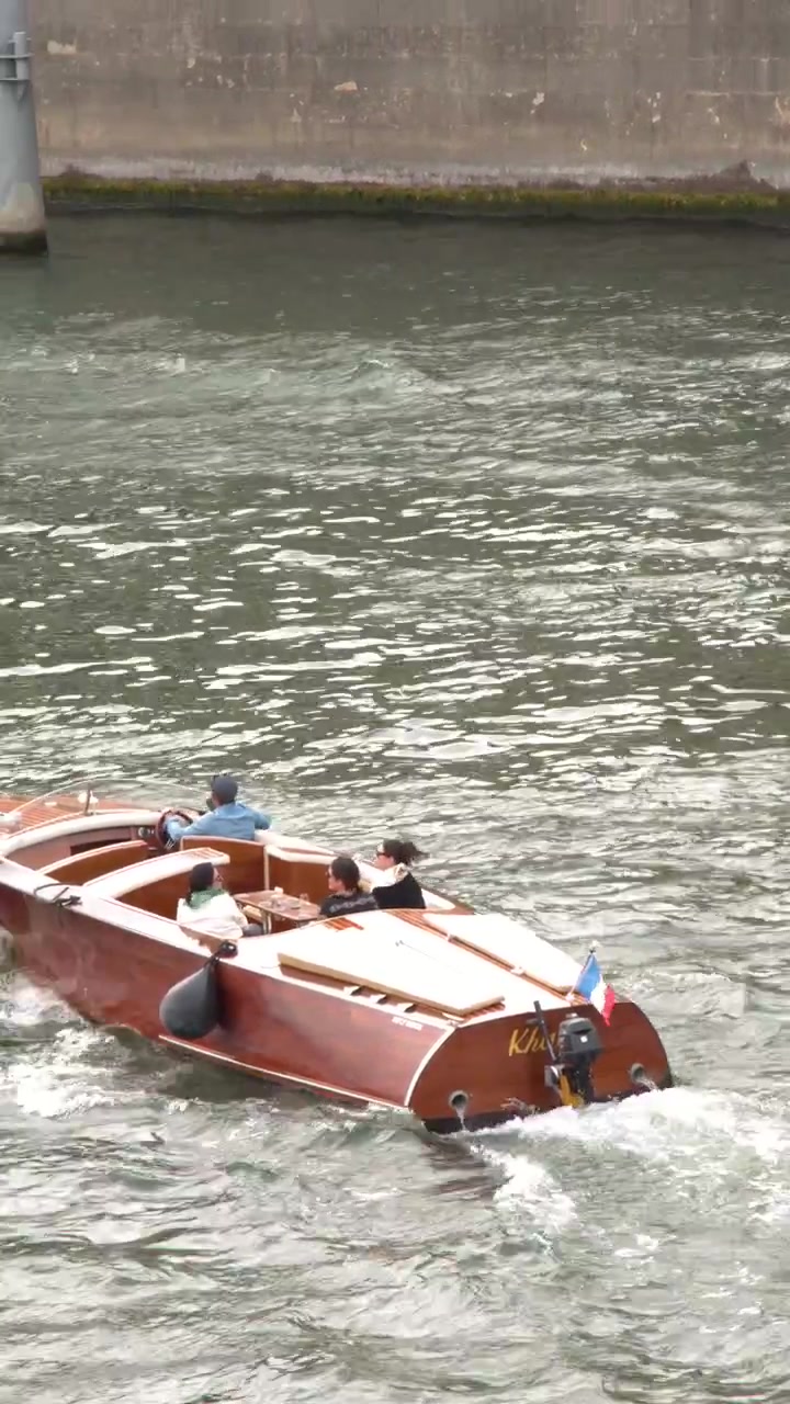 Un classico motoscafo in legno trasporta passeggeri lungo il fiume Senna a Parigi, Francia.
