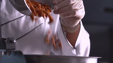 The-French-pastry-chef-adds-almonds-to-the-grain-grinding-machine