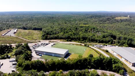 Una-Vista-Fija-De-Un-Dron-De-Un-Campo-De-Fútbol-Y-Una-Instalación-Deportiva-Que-Da-A-Un-Bosque-Exuberante-Y-Extenso