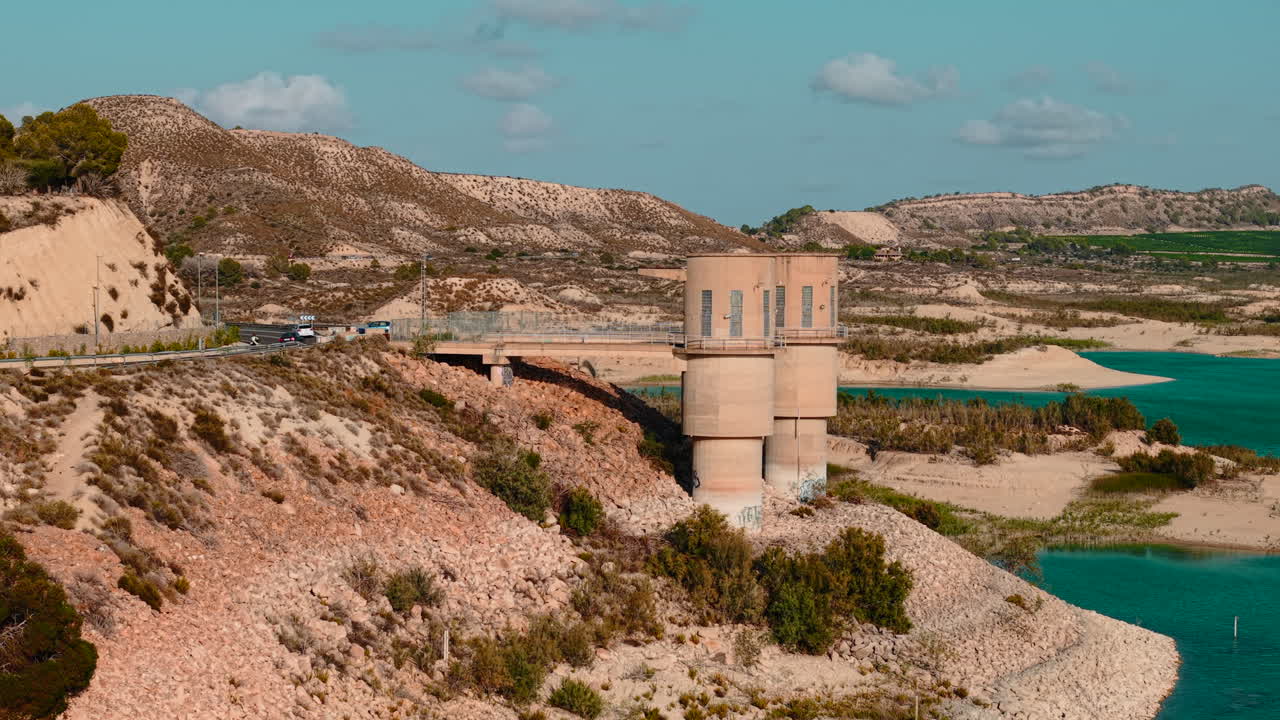 Vista panoramica di un bacino artificiale con una torre e un paesaggio montuoso