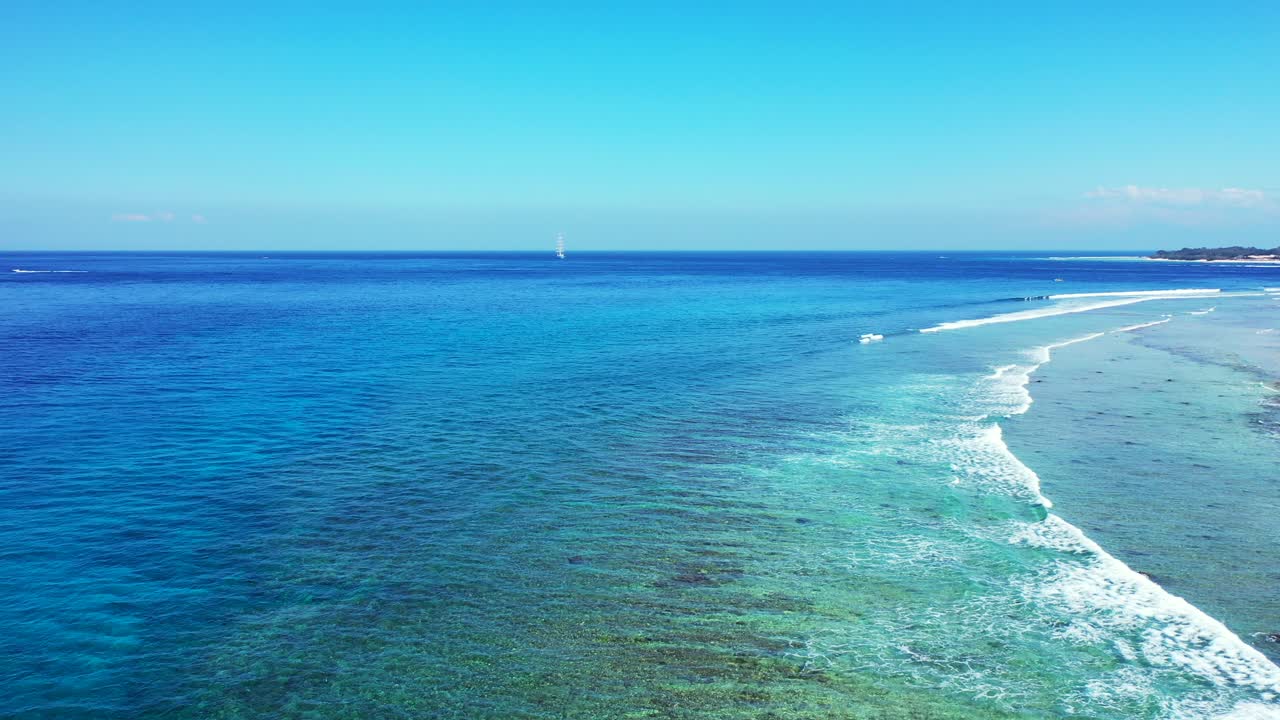 밝은 푸른 하늘 아래 바위가 많은 해저가 있는 잔잔한 청록색 석호 위로 파도가 거품이 이는 평화로운 바다 풍경, 카리브해