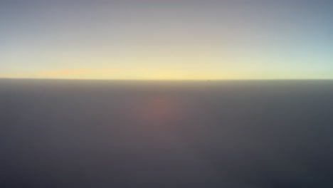 awesome sunset as seen by the pilots of a jet flying between two layers of clouds with an intense orange color sun