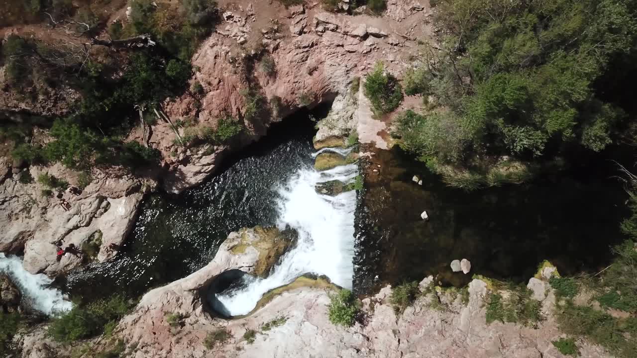 fotografía aérea de la izquierda del carro sobre la cascada y la cueva de fossil springs, arizona