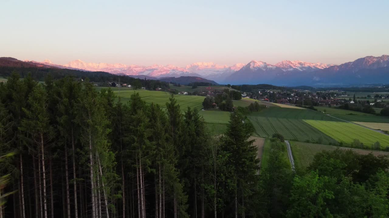 Ilmakuva metsästä ja Sveitsin vuorista iltahämärässä