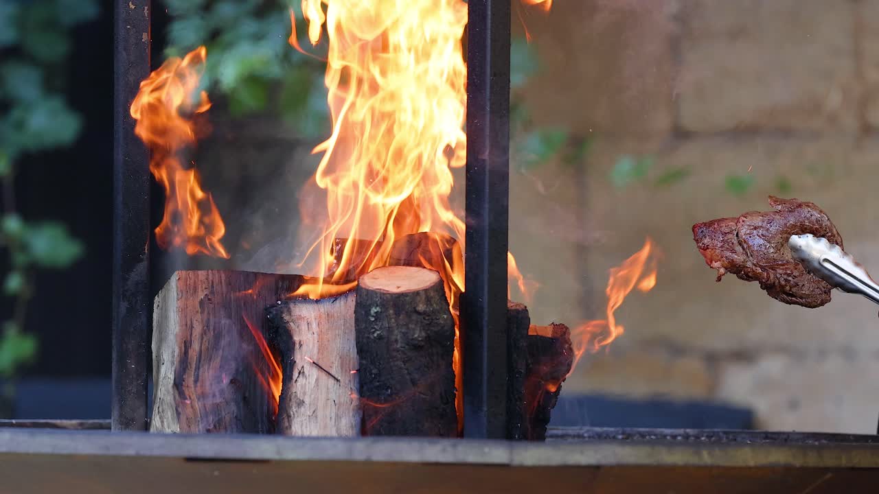 나무 불 위 에 고기 를 고 있는 것