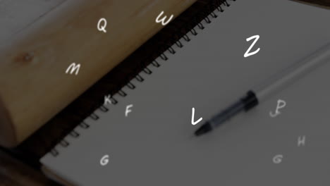 animation of floating letters over a pen lying on a notebook