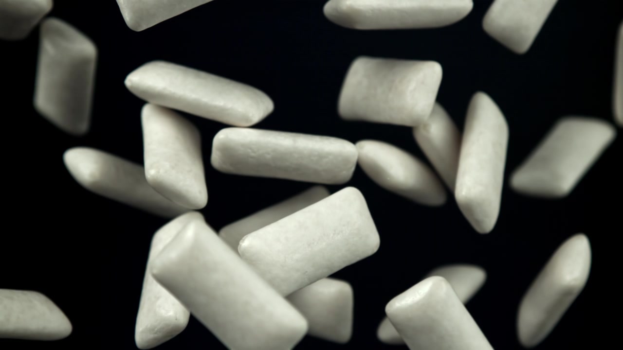 Pezzi di gomma da masticare bianca che cadono in super slow motion