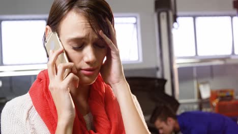 mujer tensa hablando por teléfono móvil