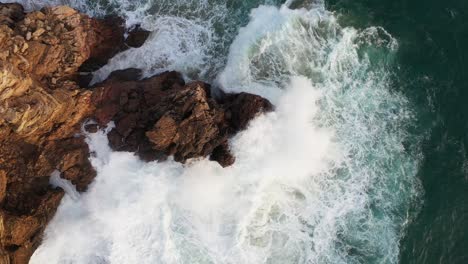 Roca-Oceánica-Golpeada-Por-Las-Olas-En-Praia-Do-Tonel,-Cerca-Del-Cabo-Sagres-Portugal,-Tiro-Aéreo-En-Círculo-Ascendente