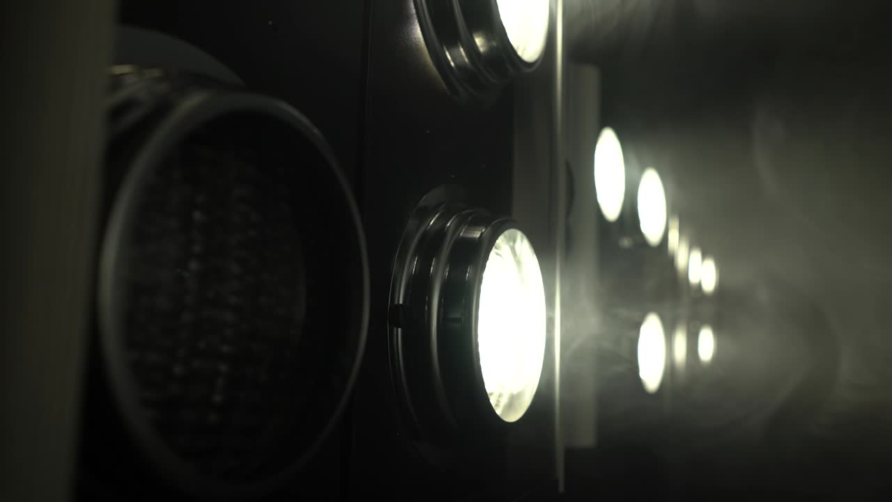 Large projectors with flickering light create color music . Close up