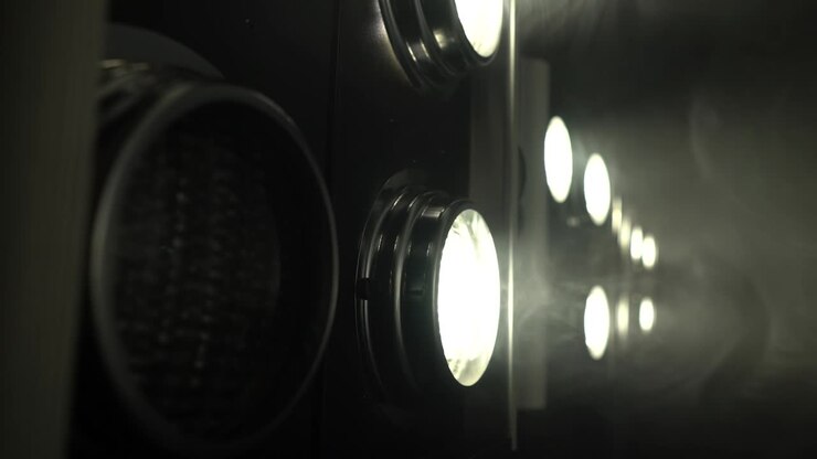 Large projectors with flickering light create color music . Close up