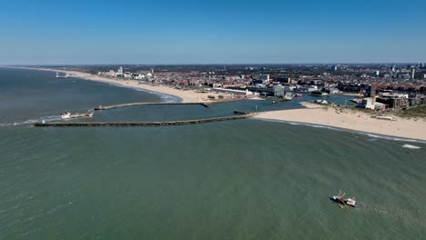 large fishing trawler, trawling nets, side on aerial shot slow motion, city in the background