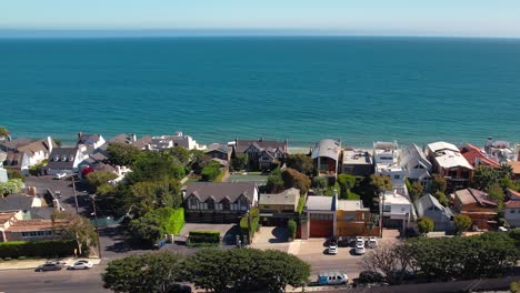 Beautiful-establishing-drone-shot-of-seafront-homes-on-Malibu-beach-in-summer-sun