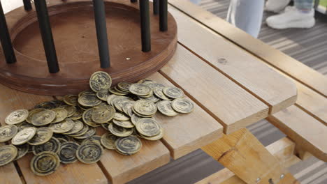 gold coins on wooden picnic table