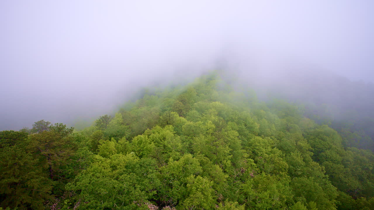Drone shot capturing ethereal fog over mountain tops