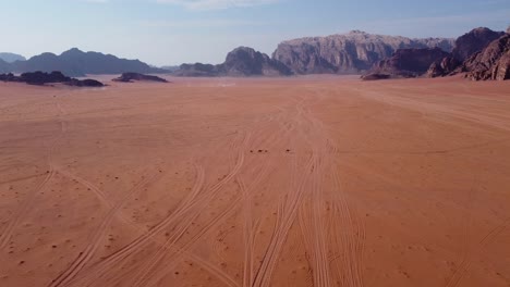 aerial view of a camel family walking through the wadi rum desert in jordan