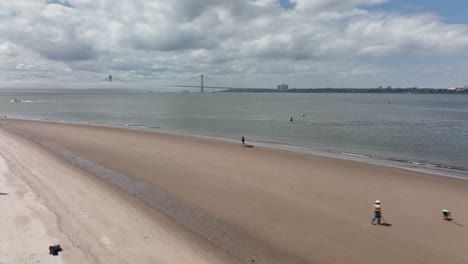 A-low-angle-view-of-the-beach-on-Gravesend-Bay-in-Brooklyn,-NY-on-a-beautiful-day-with-blue-skies-and-white-clouds