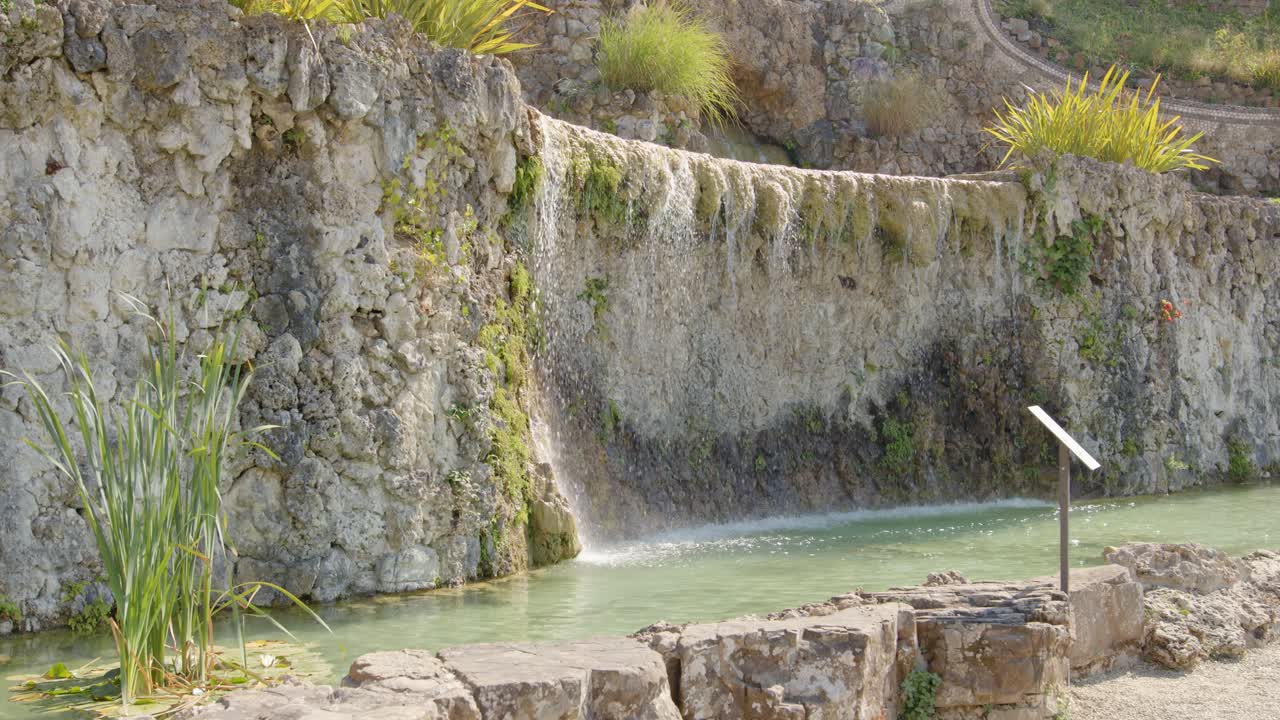 el agua se escurre por una fuente de piedra natural