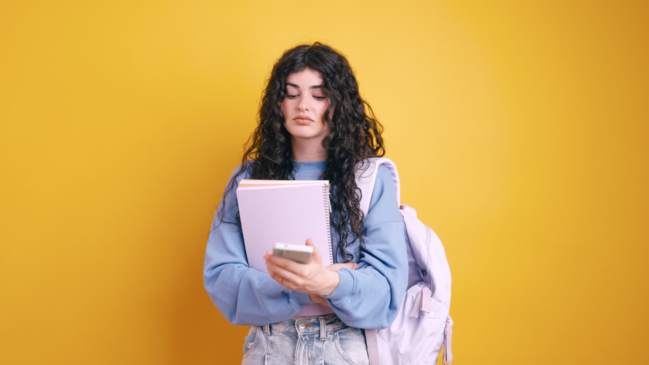 Young female student with books and smartphone