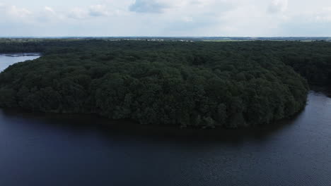 flying over trémelin or tremelin lake at low altitude over water surface, brittany in france