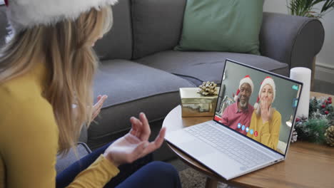 Feliz-Pareja-De-Ancianos-Diversos-Y-Amiga-Teniendo-Videollamada-Navideña-Con-Computadora-Portátil,-Cámara-Lenta