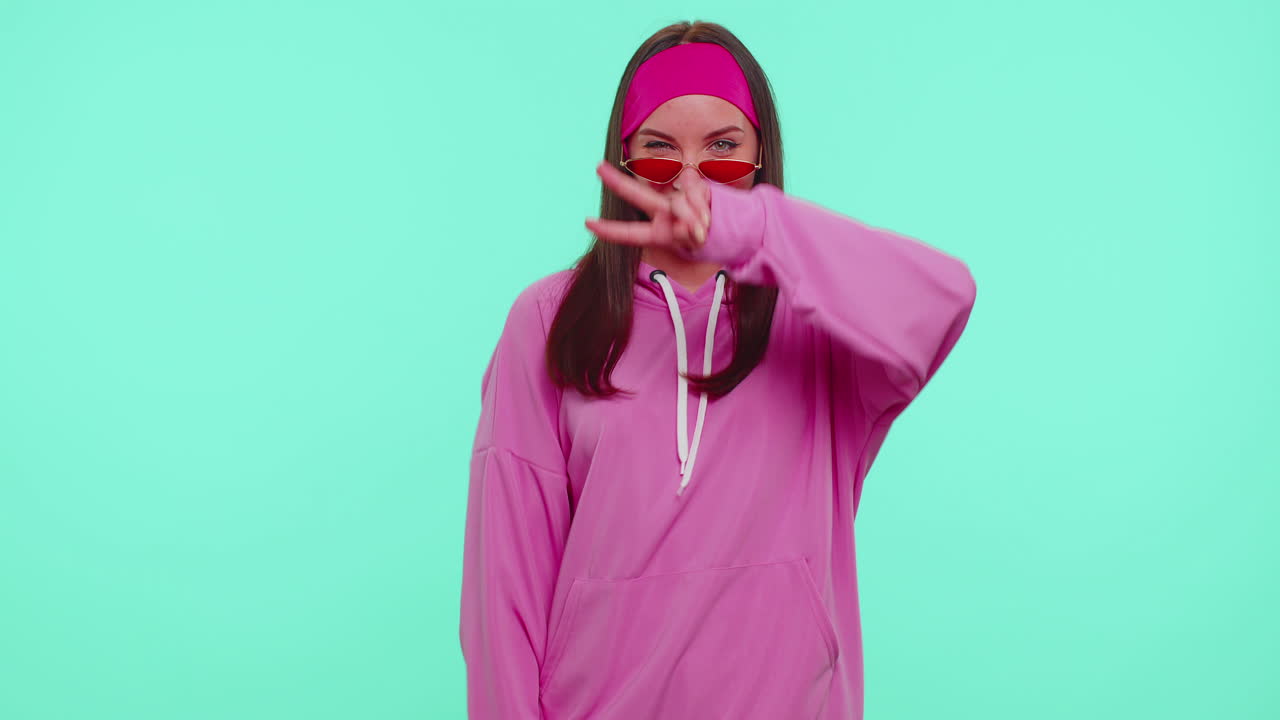 Glad attraktiv pige i solbriller, der lytter til musik og danser disco, laver sjov og har det sjovt