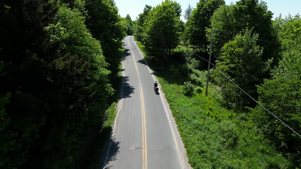 Cykloturysta jadący na rowerze, wspinający się na górę w Estrie, Quebec, Kanada