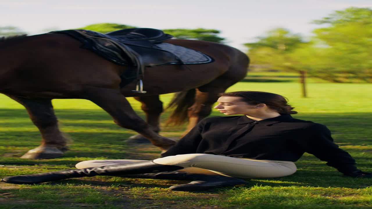 Woman sitting next to a horse in a field