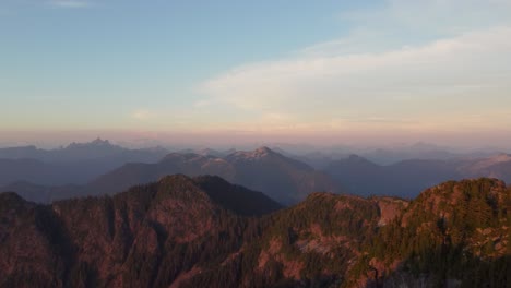 Hermosa-Puesta-De-Sol-Panorámico-Drone-Aéreo-Tomado-Desde-El-Pico-Deeks-Con-Una-Vasta-Cordillera-Y-Un-Increíble-Horizonte-Naranja-Iluminado-Rangos-Pacíficos-Canadá-Bc-4k