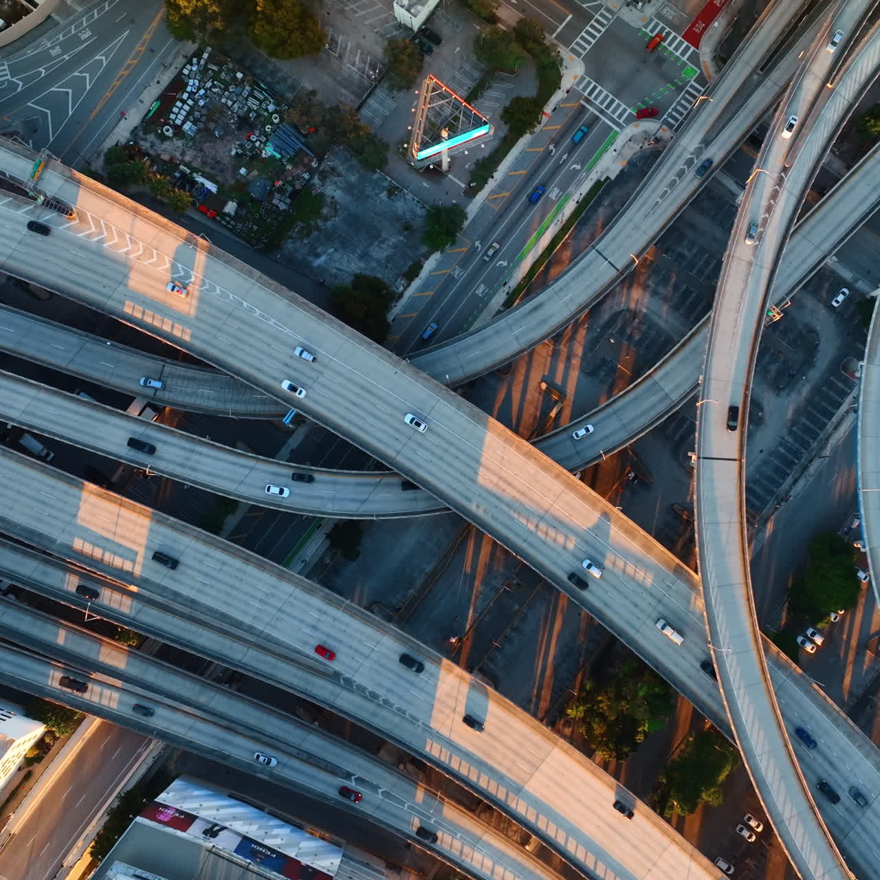Few speedways entwining in the downtown of big city. Some cars run by the highways. Top view.