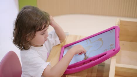 toddler girl drawing on a tablet