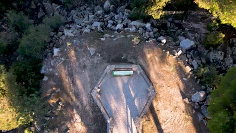 tomada de un dron de arriba hacia abajo de una plataforma artificial rodeada de bosques verdes en españa