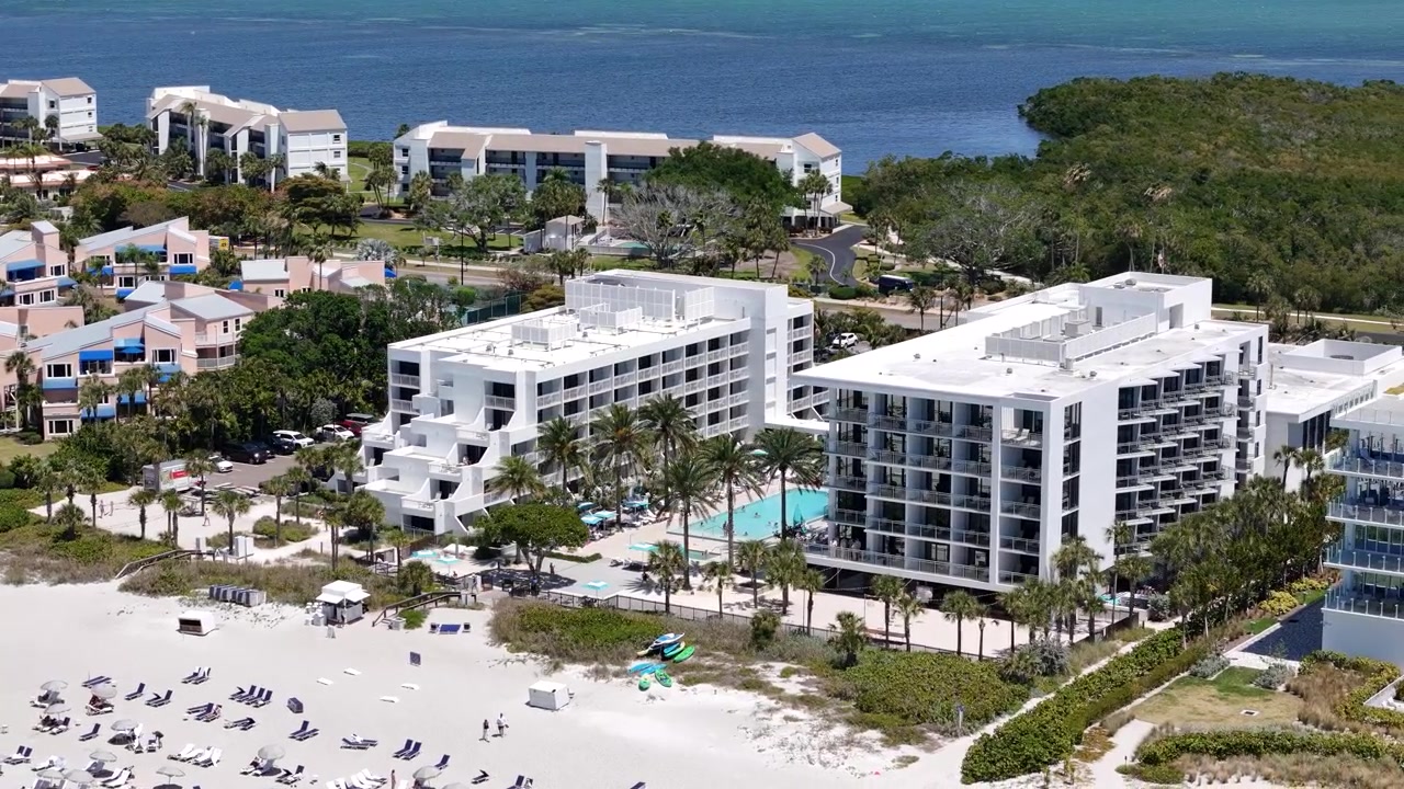 Záběr dronem na plážové hotely a bazén na Longboat Key, Florida, USA.
