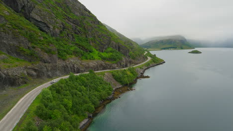 panorámica sinuosa carretera costera muestra la belleza natural de lofoten noruega, dolly aérea