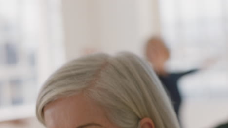 close up portrait beautiful old woman exercising yoga class meditation practicing warrior pose enjoying group physical fitness workout in studio