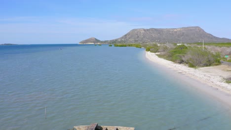 Holzboot-Auf-Der-Ruhigen-Seelandschaft-In-Monte-Cristi,-Dominikanische-Republik---Luftdrohnenaufnahme