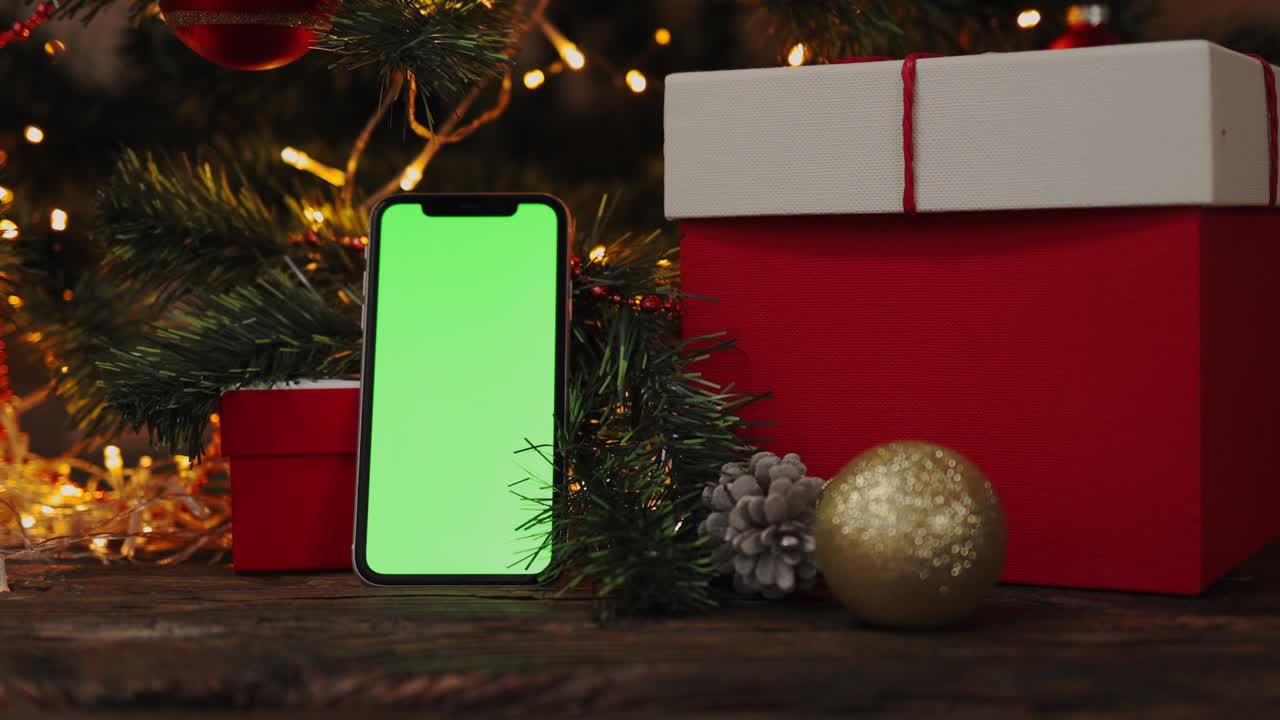 fondo de navidad caja de regalo roja teléfono inteligente gadget pantalla verde luces parpadeantes