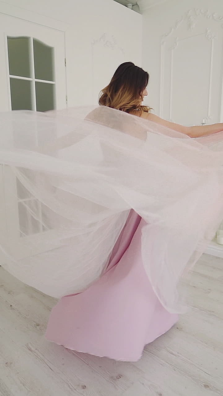 Beautiful bride in luxury hotel room. View of young happy bride in dress in room Vertical video