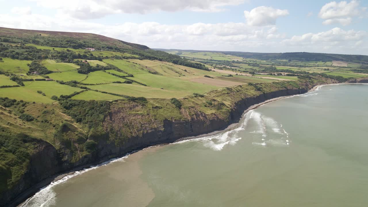 toma panorámica aérea de la costa del norte de yorkshire, ravenscar con campos verdes y el océano