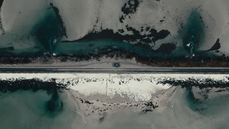 top view of a car parked on the road bridge in lofoten island, norway. aerial descending shot