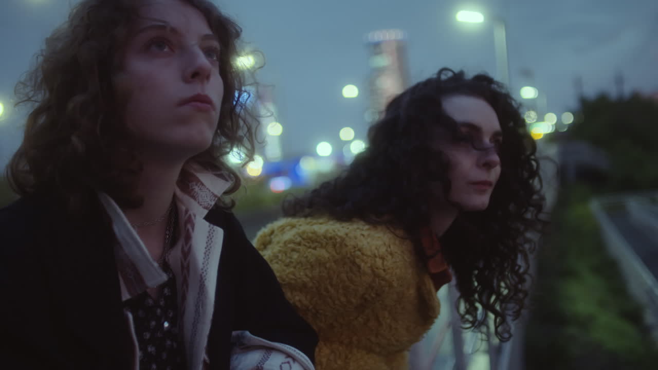 Girls Leaning on Railing on Dark City Street
