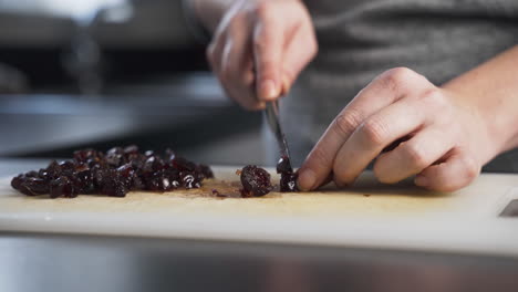 close up view of glazed cherries being chopped and sliced to make mince pie filling